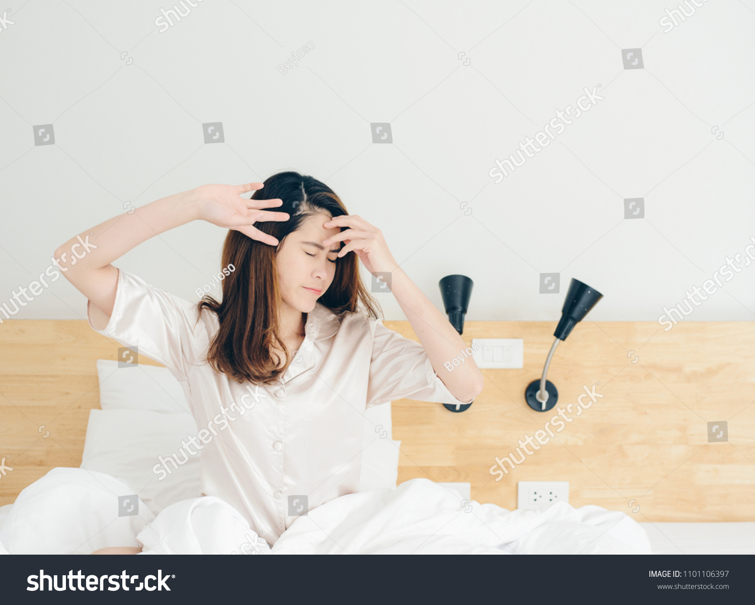 Portrait of Asian woman stretching in bed after wake up. Woman lifestyle after wake up.
