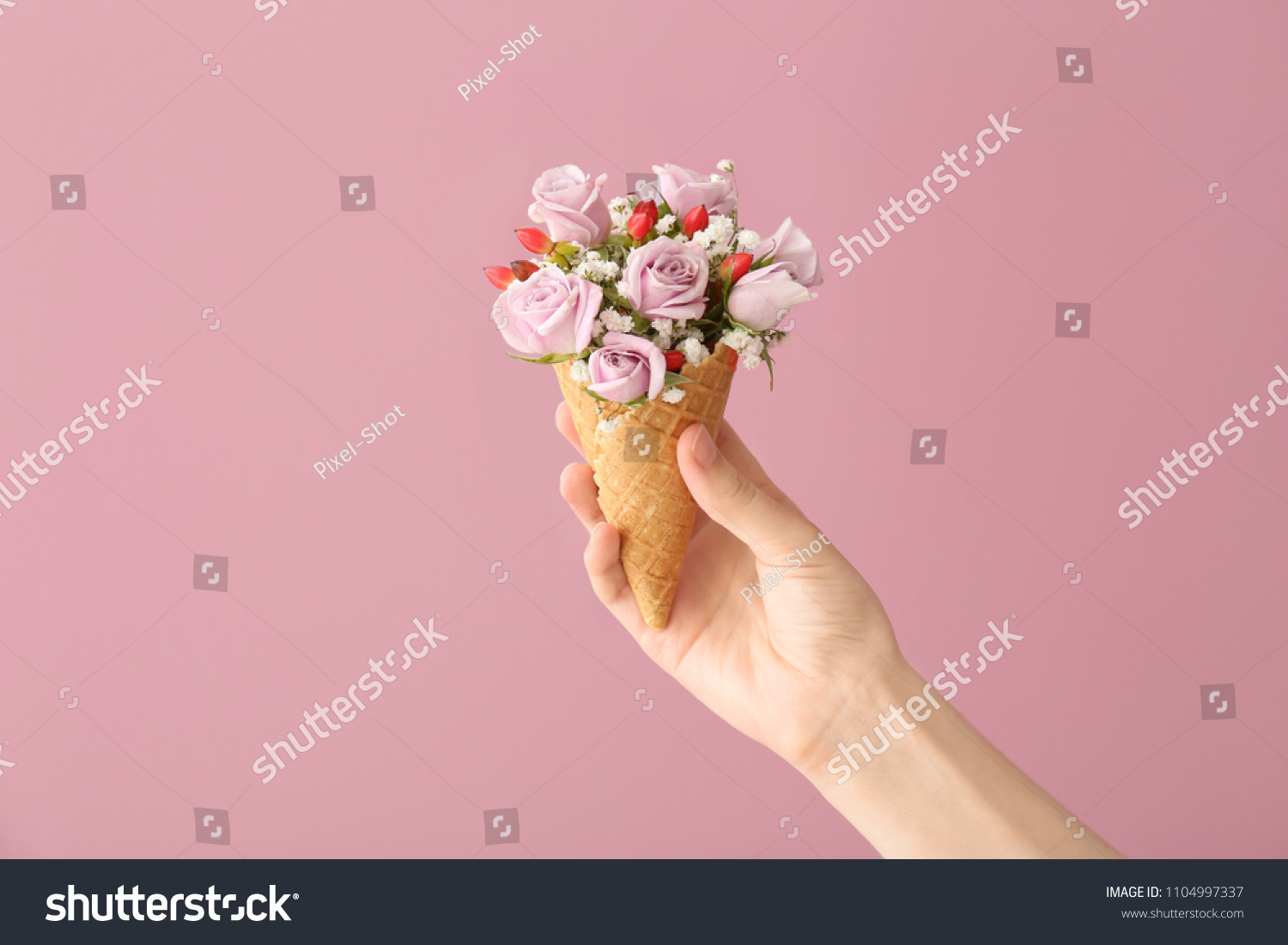 Woman holding waffle cone with beautiful flowers on color background