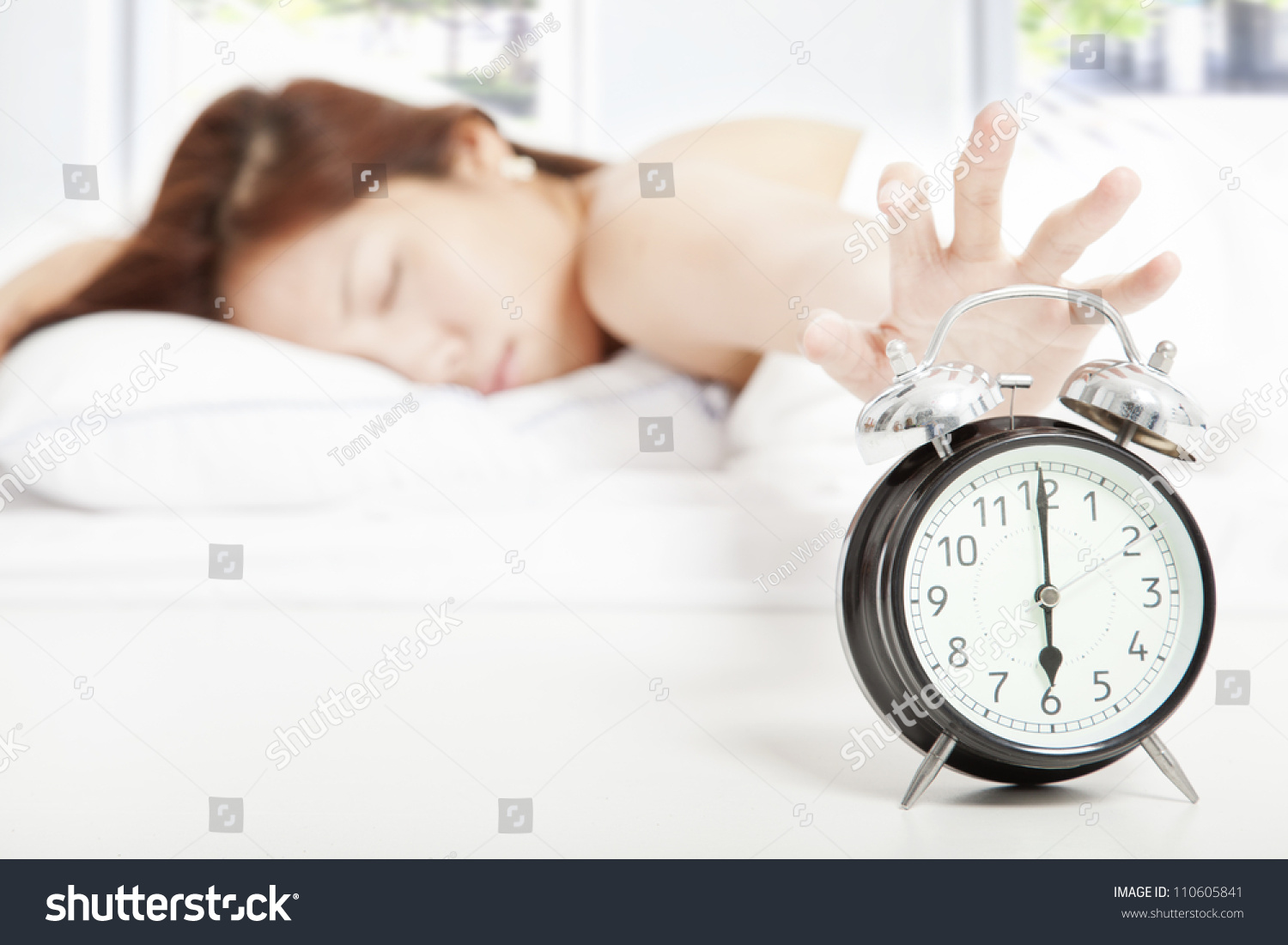 Woman turning off the alarm clock