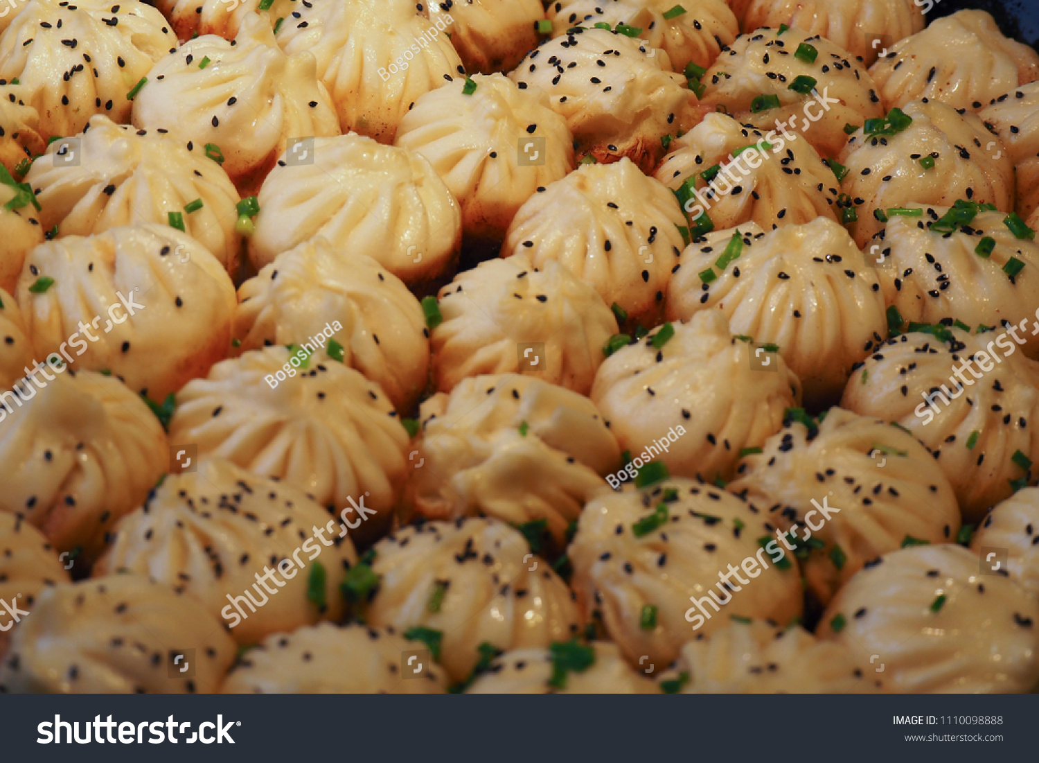 big frying pan with sheng jian bao-traditional chinese pan fried dumplings with minced pork shrimp and vegetables in Shanghai China Cantonese food pan-fried