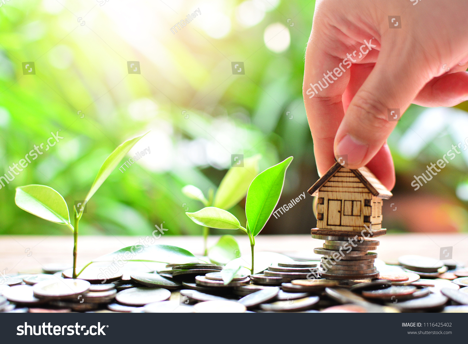 hand putting house model on coins saving for concept investment fund mortgage finance and home loan 