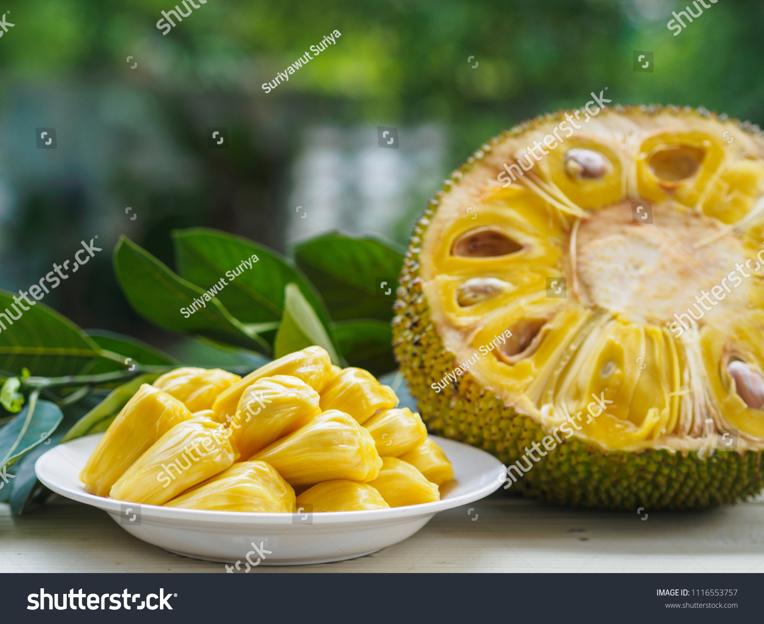 Fresh Jackfruit in white dish  half of jack fruit and jackfruit leaf on wooden table.