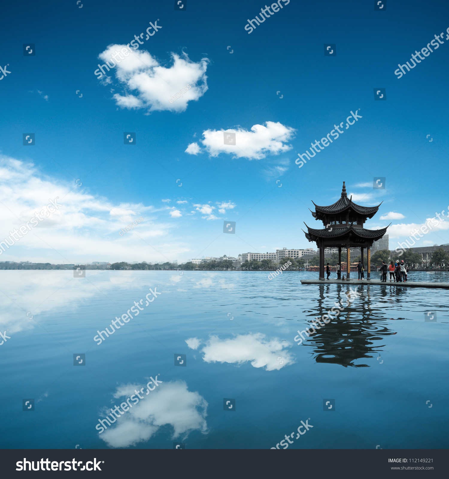 ancient pavilion against a blue sky and reflection in the west lake at hangzhou China.