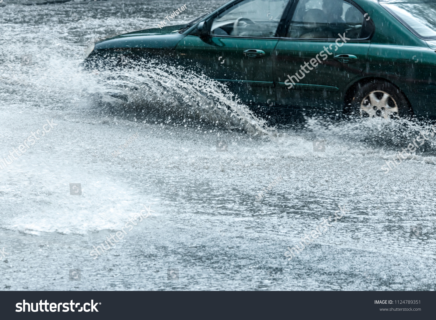 splashes of rain water from car wheels during heavy rain