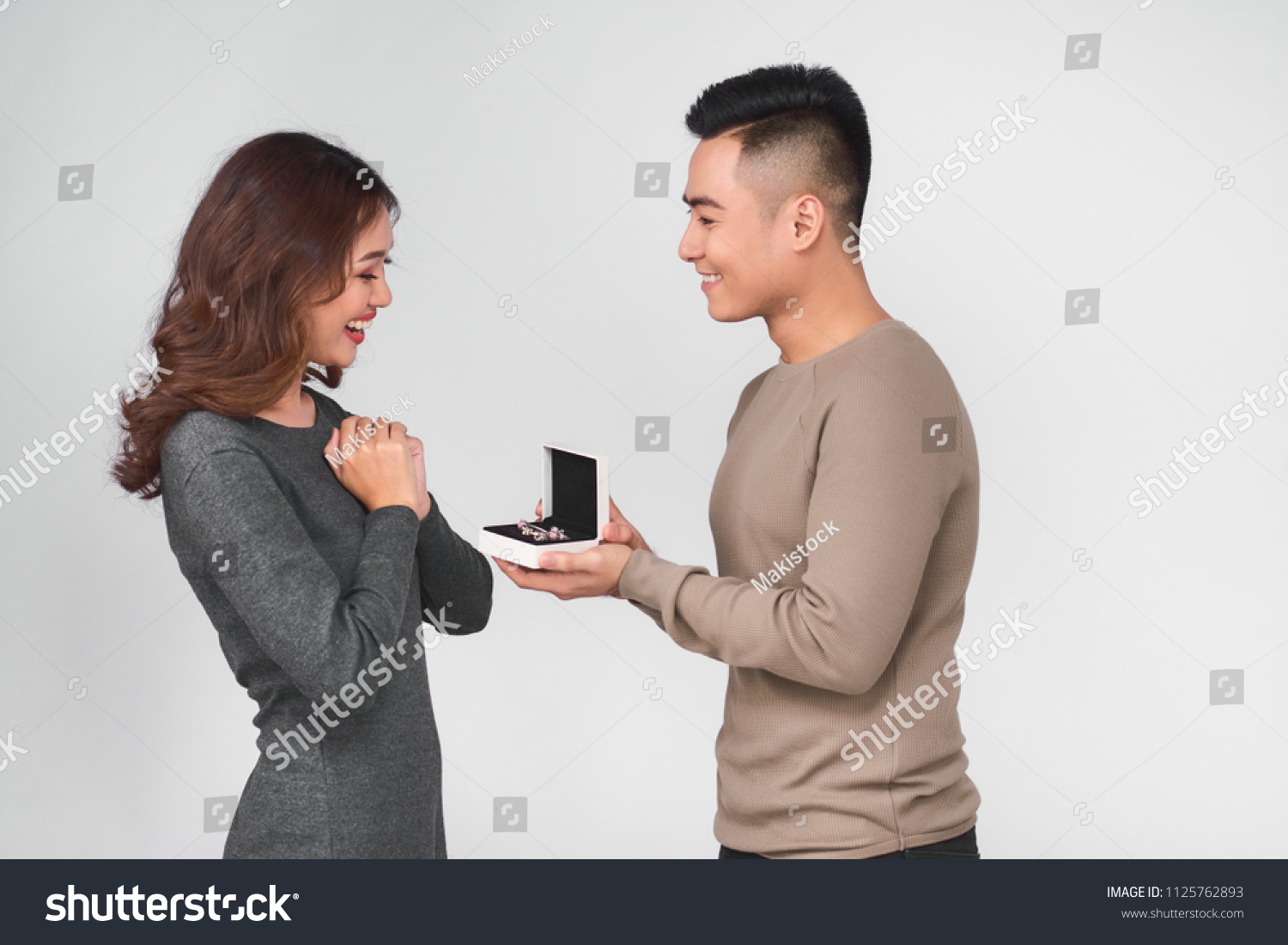 Asian man gives jewelry in a box to his woman