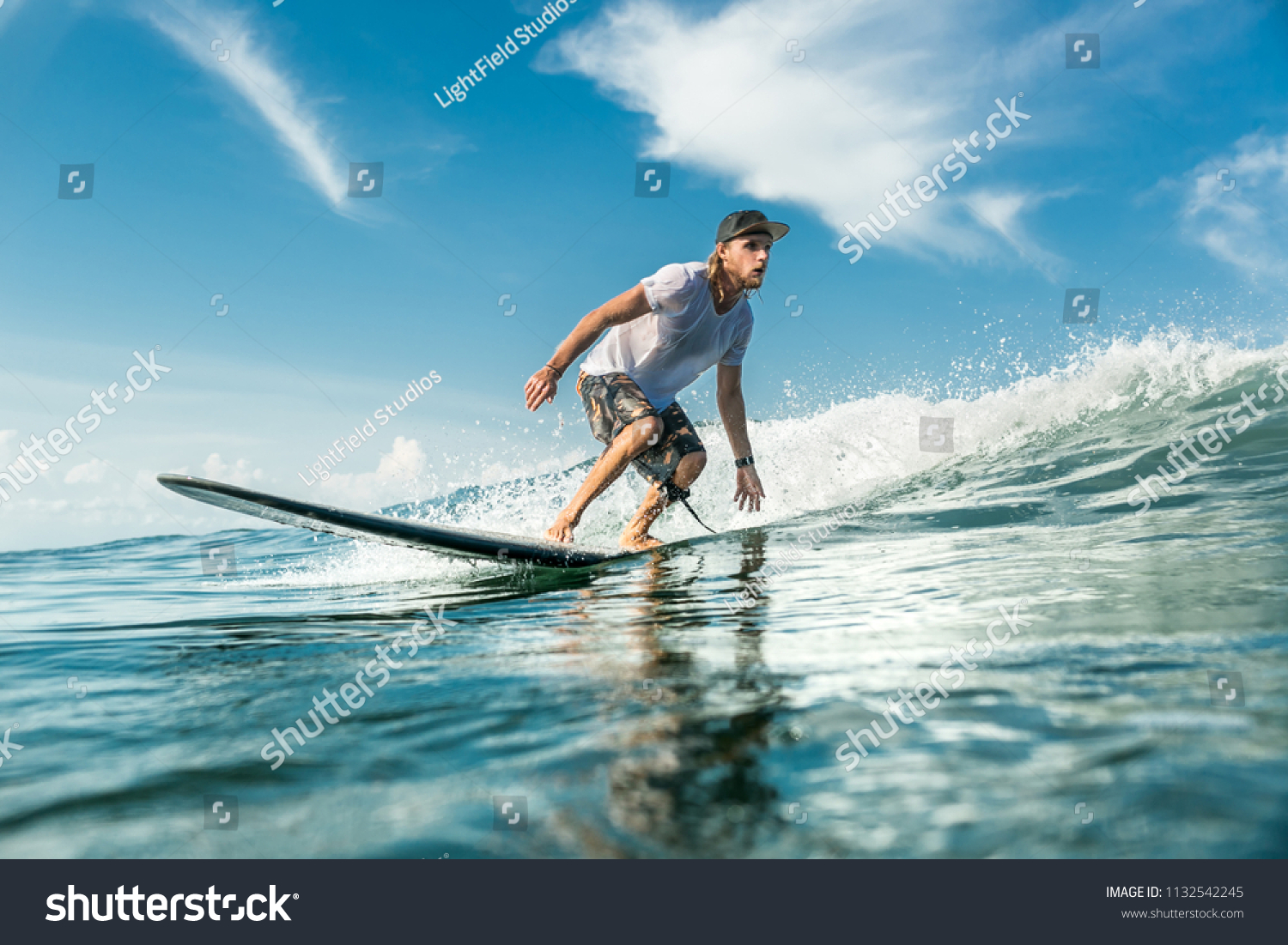 young male surfer riding waves in ocean at Nusa Dua Beach  Bali  Indonesia