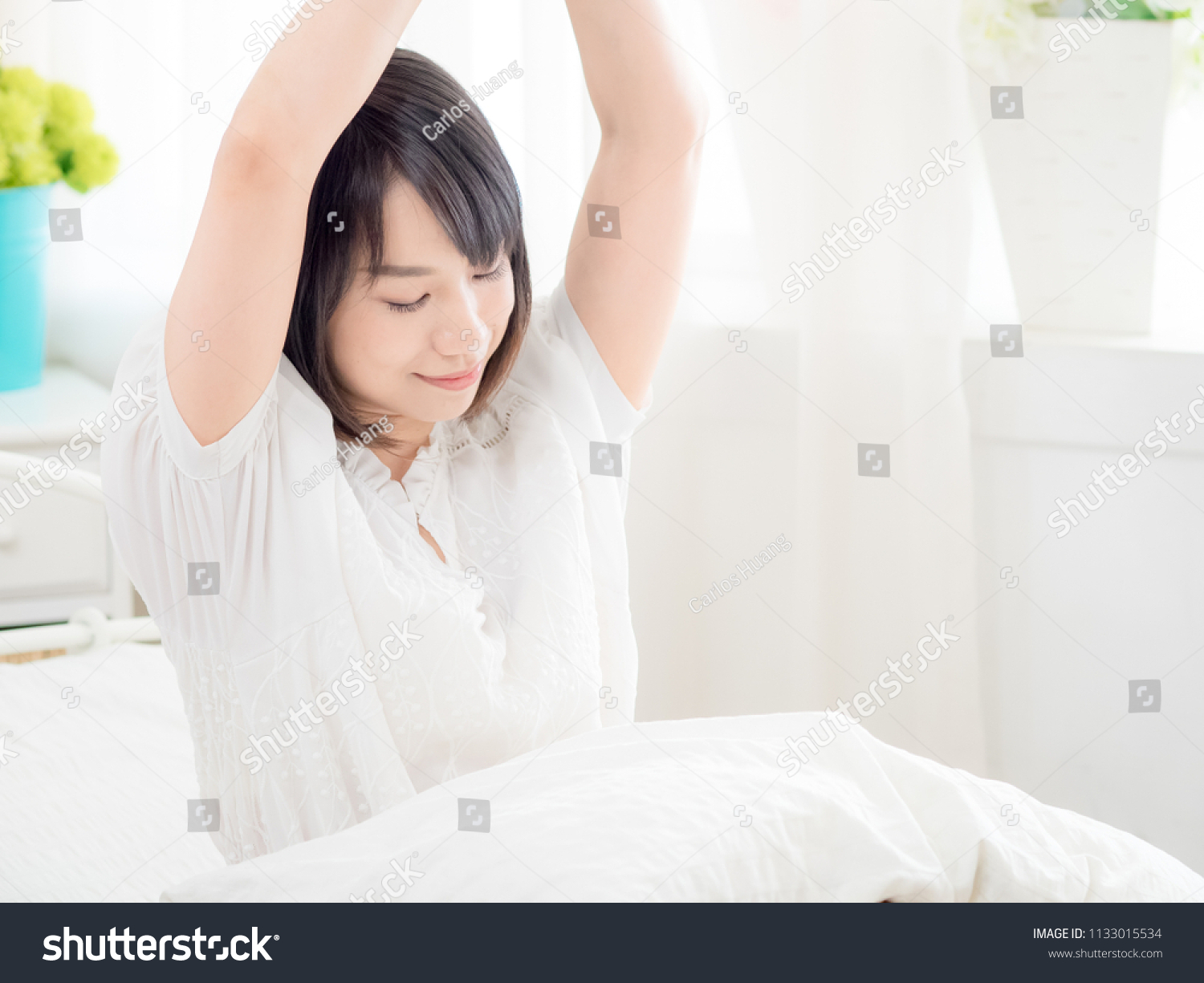 girl waking up stretching arms on the bed in the morning