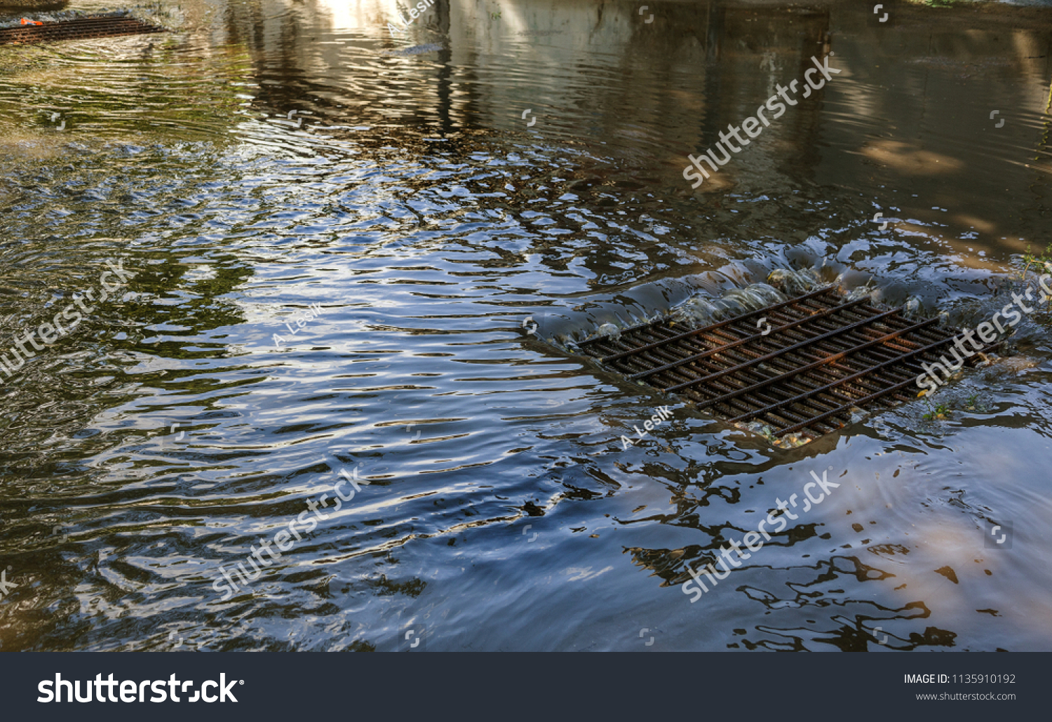 Flow of water during heavy rain and clogging of street sewage. The flow of water during a strong hurricane in storm sewers. Sewage storm system along the road to drain rain into the drainage system