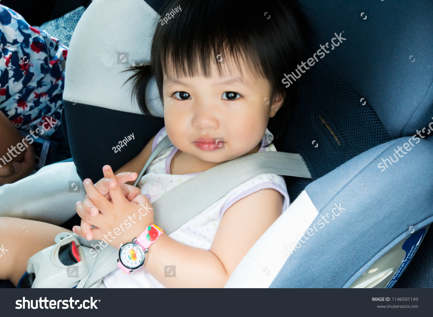 Portrait of cute toddler girl sitting in car seat. Child transportation safety