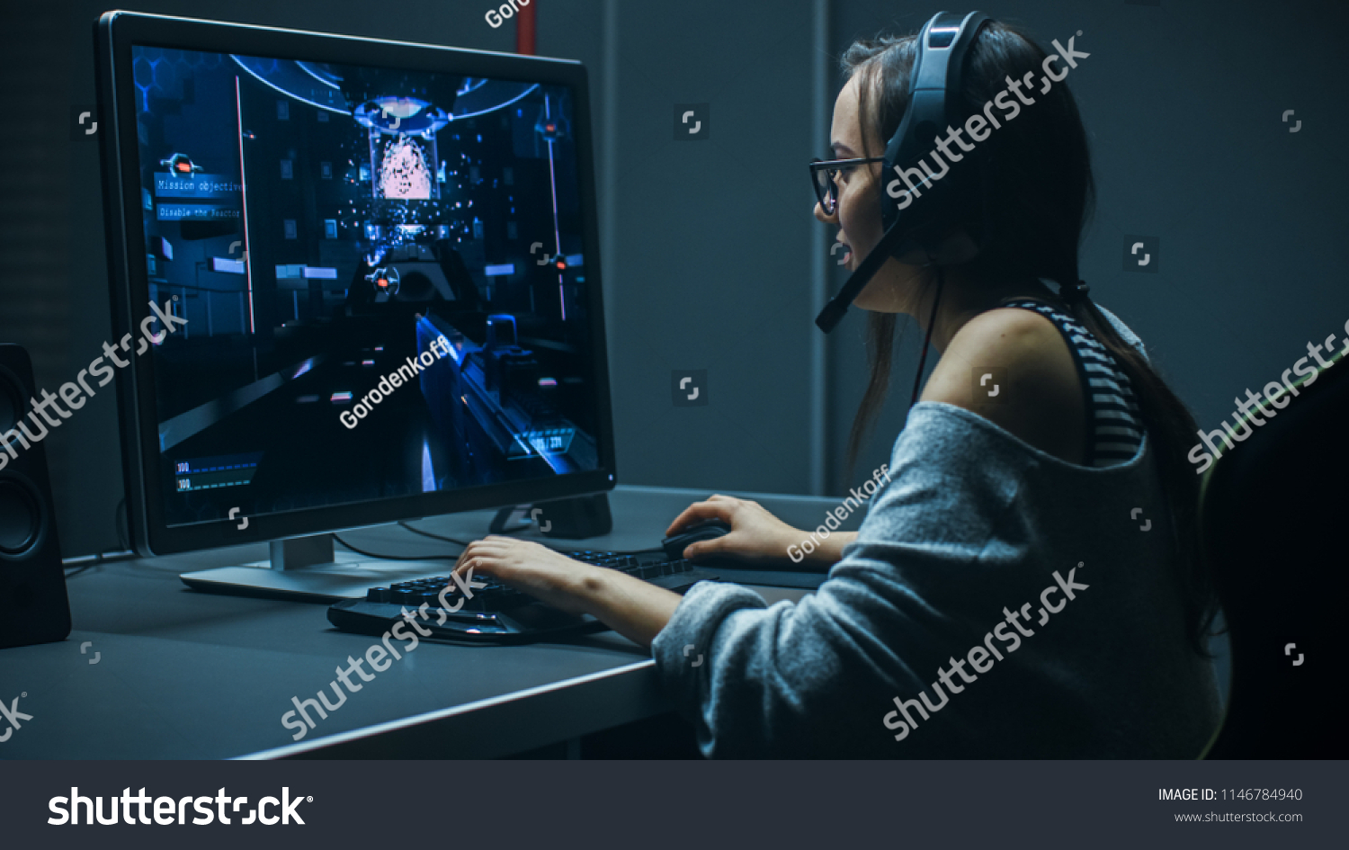 Beautiful Professional Gamer Girl Playing in First-Person Shooter Online Video Game on Her Personal Computer. Casual Cute Geek Girl Wearing Headset. In the Underground Gaming Club.