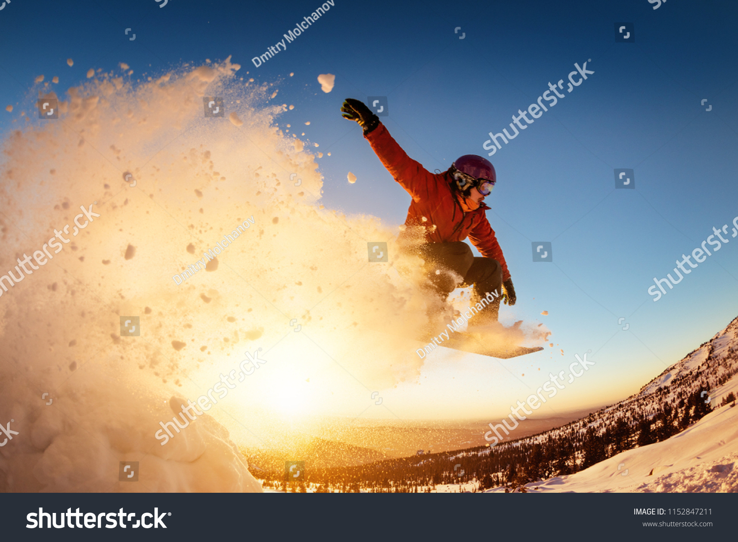 Snowboarder jumps or flies against sunset light with snow dust