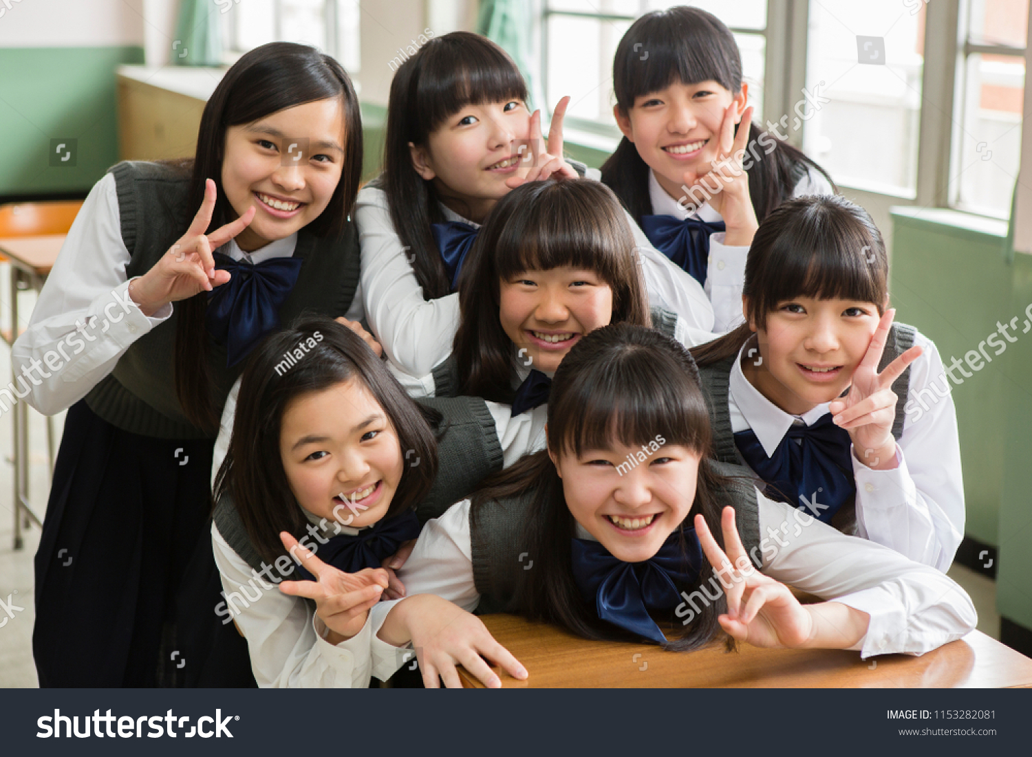Female students of Japanese to peace sign