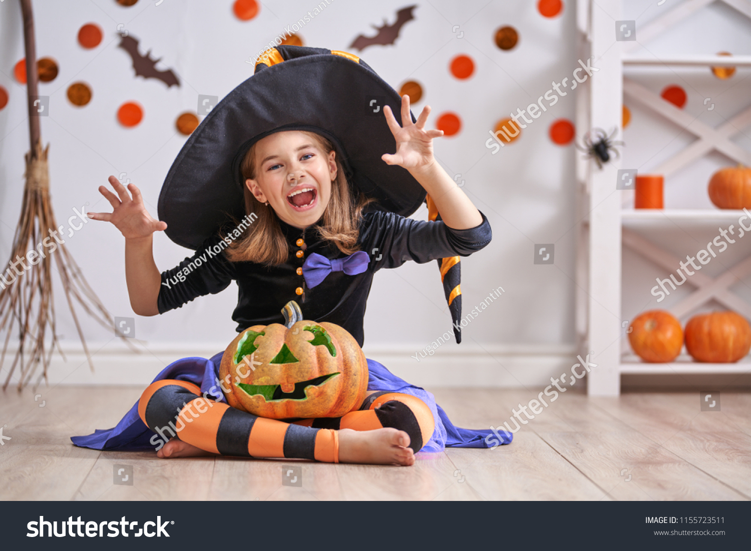 Happy Halloween! Cute little laughing girl in witch costume with a ...