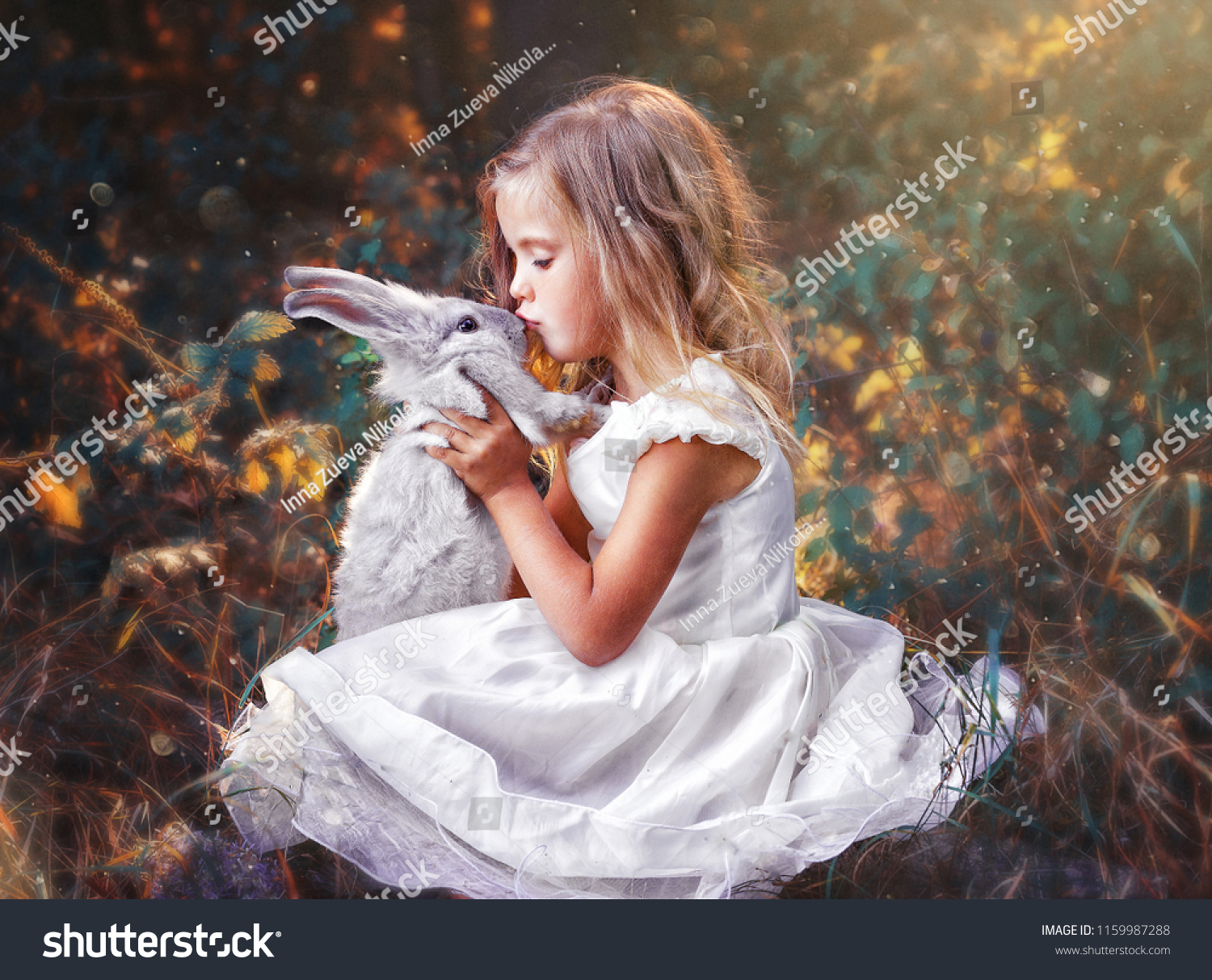 Children in beautiful white dress play with rabbit. Little girl holding in hands little rabbit.