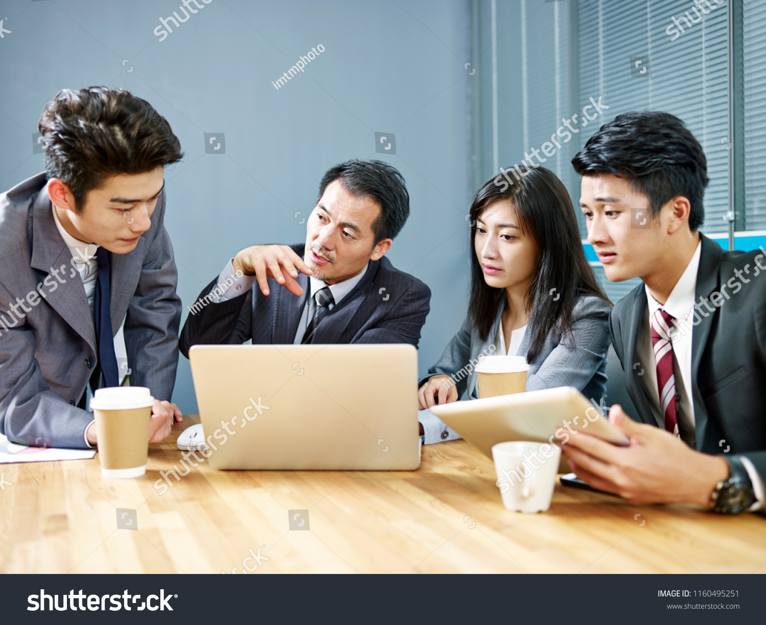 asian corporate people meeting in office discussing business using laptop computer.