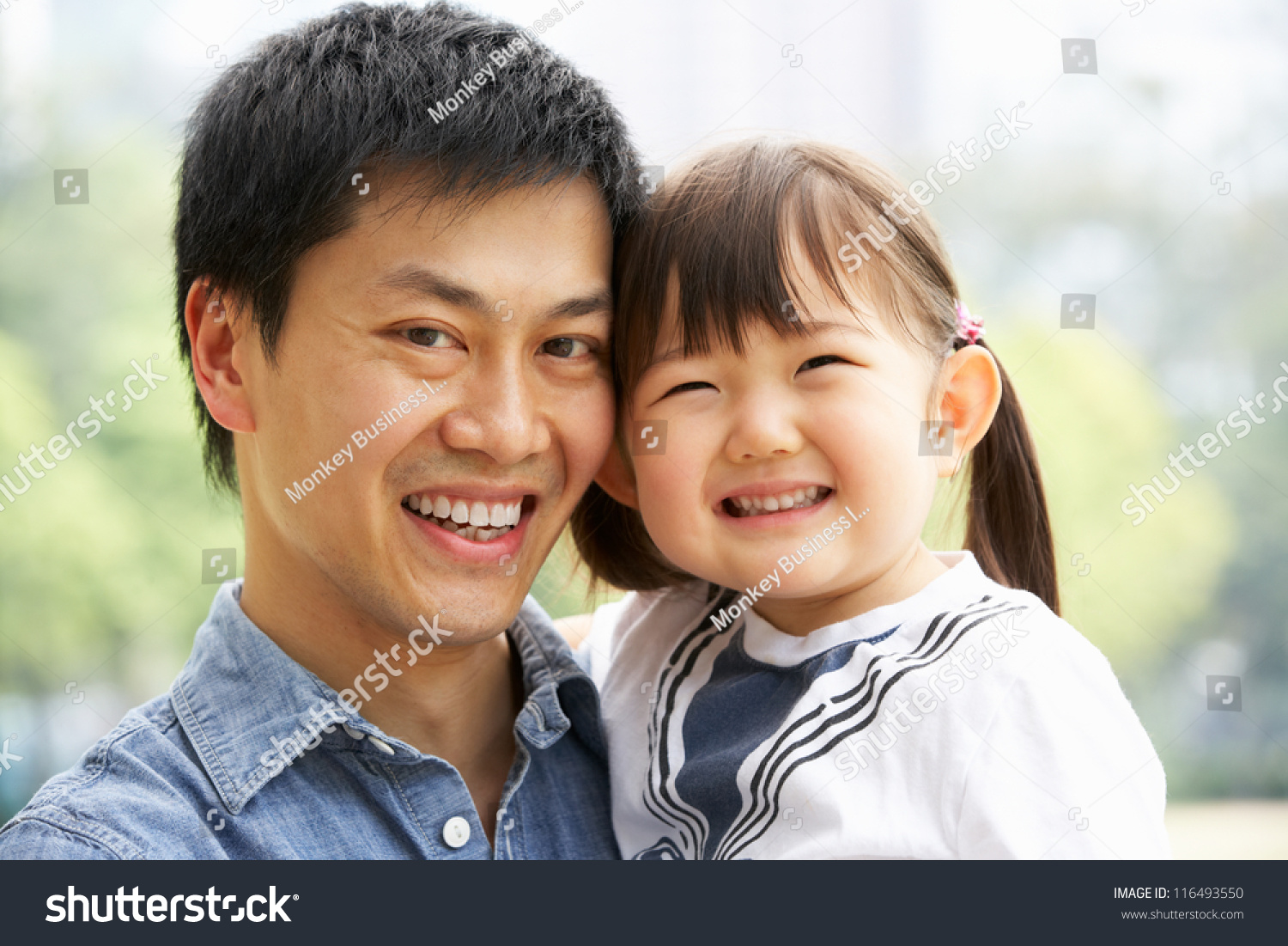 Portrait Of Chinese Father With Daughter In Park