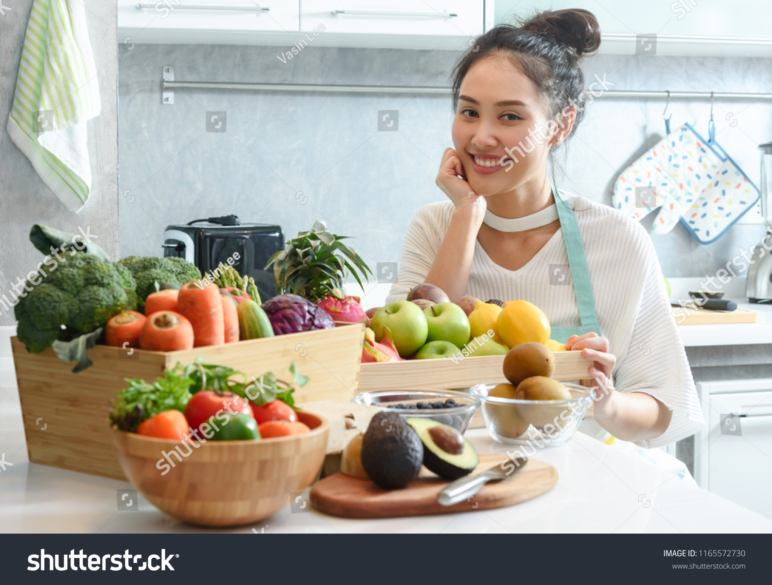 Woman in kitchen with various kind of vegetable and fruits that all are good for health and no meat  vegan lifestyle
