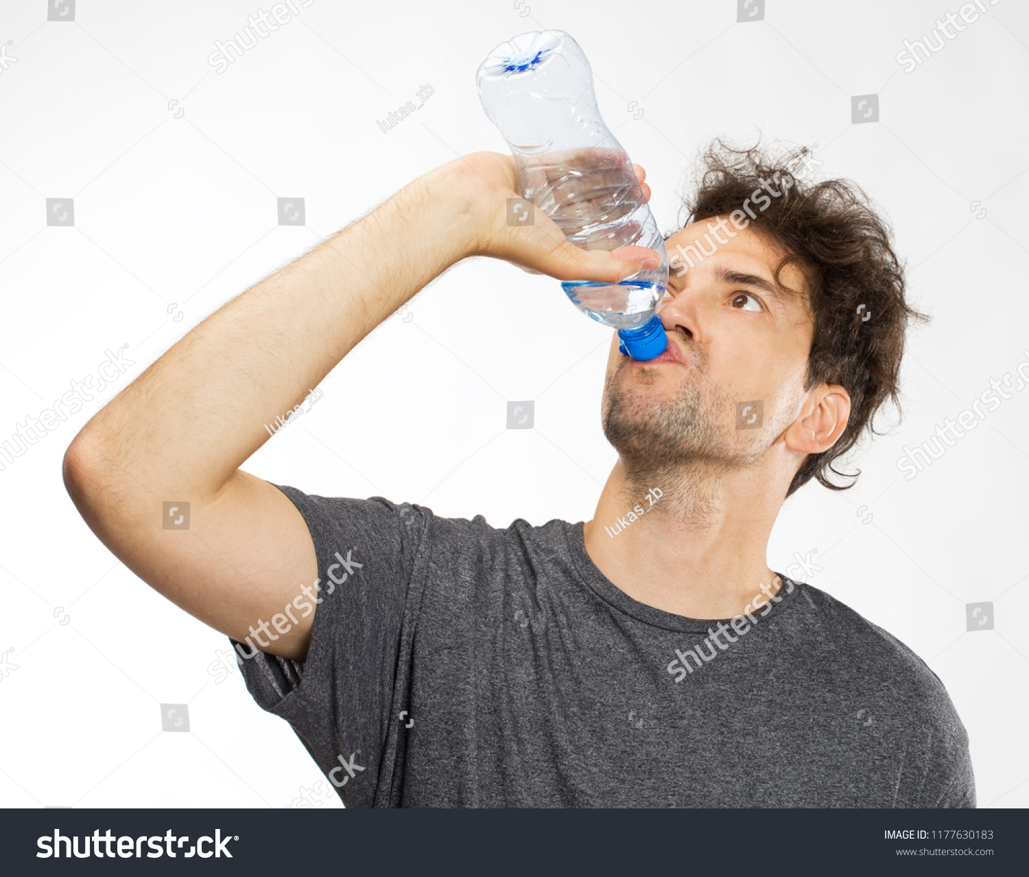 Portrait of cheerful young man drinking water