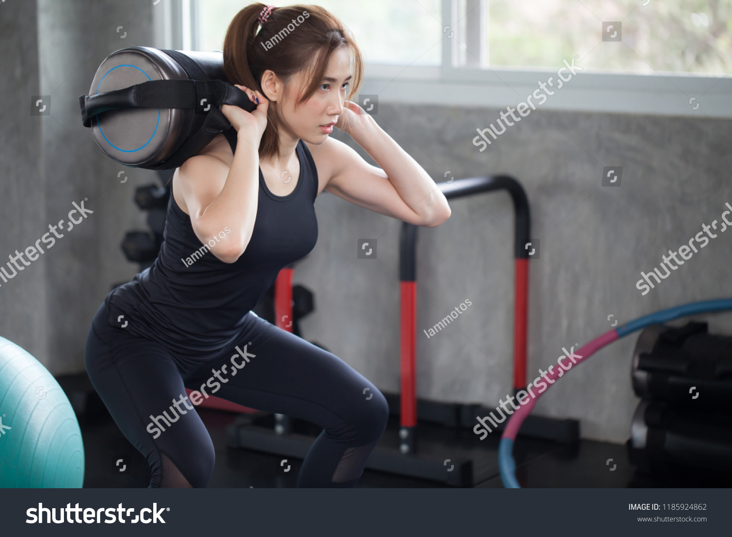 asian sport woman in sportswear exercise squat with with training weight bag in fitness gym . young girl workout with lifting weights bags. building muscles  bodybuilding.