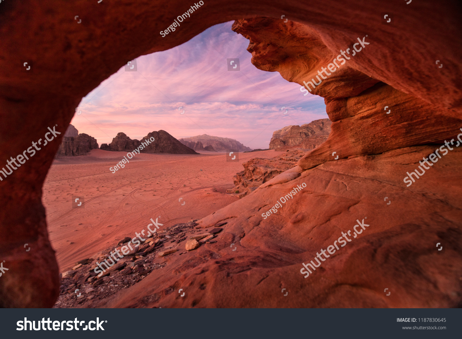view from natural cave to pink sky in sunset in desert