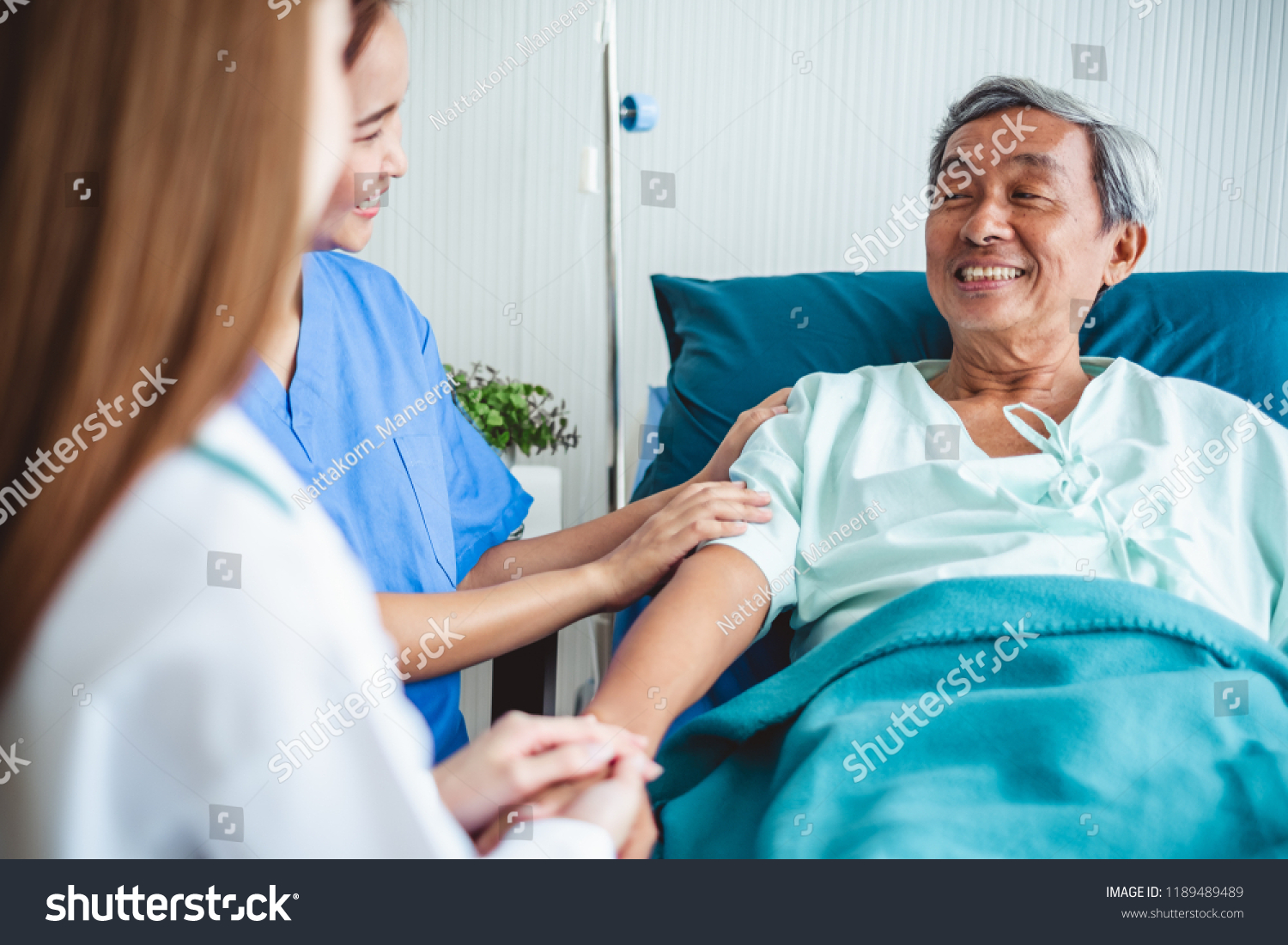 Asian doctor woman encourage disabled old patient by holding hand