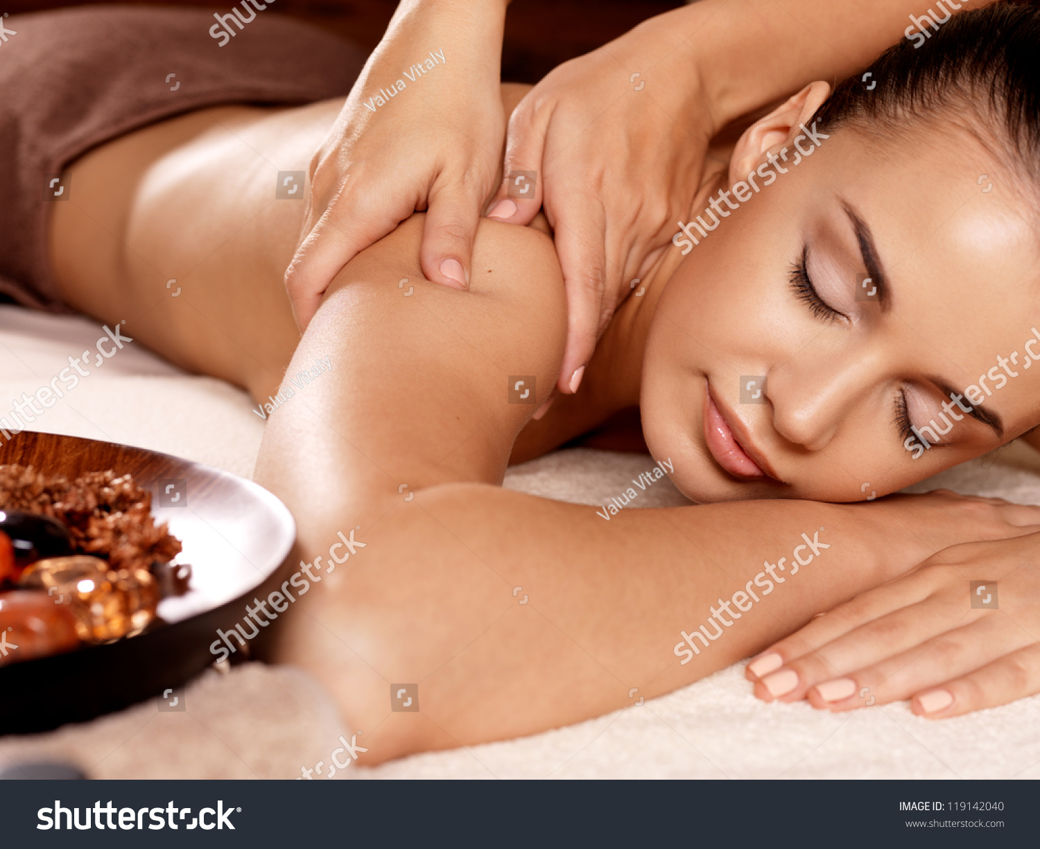 Masseur doing massage on woman body in the spa salon. Beauty treatment concept.