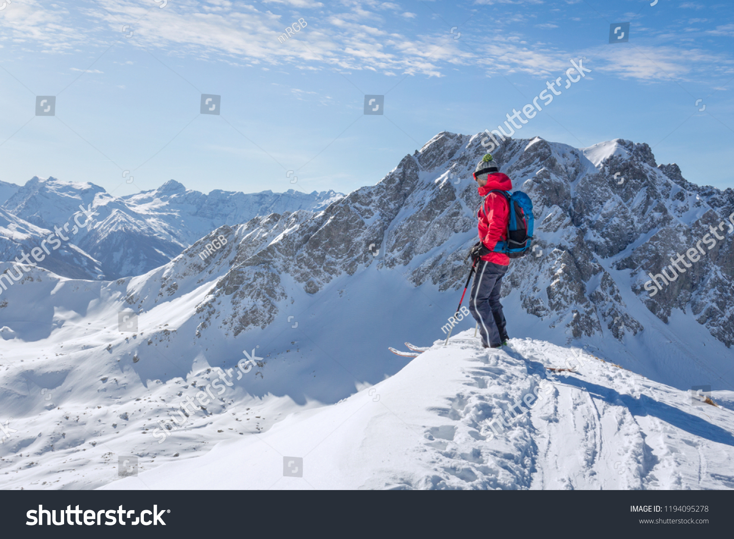 Male ski tourer enjoying the view on a summit in the alps