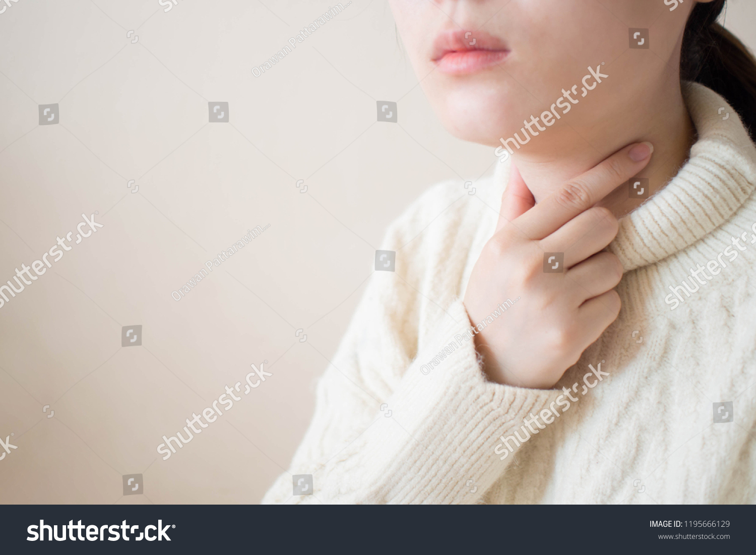 Sick woman suffering from sore throat on gray background. Causes of throat pain include flu  common cold  bacterial infections  pneumonia or allergies. Health/medical concept. Close up. Copy space.
