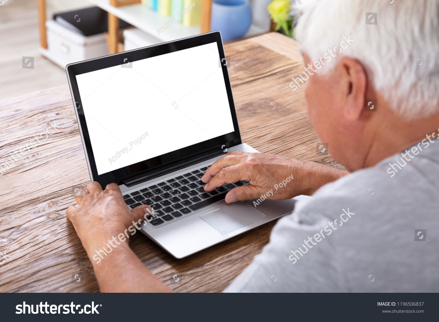 Senior Man Using Laptop With Blank White Screen