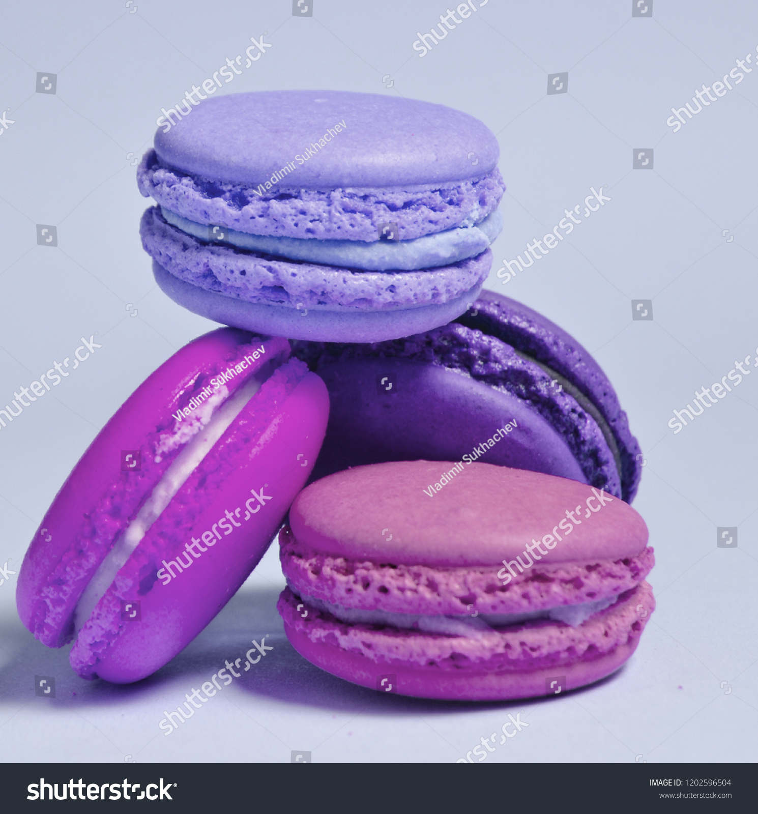 Many macaroons on violet neon background. Minimalism
