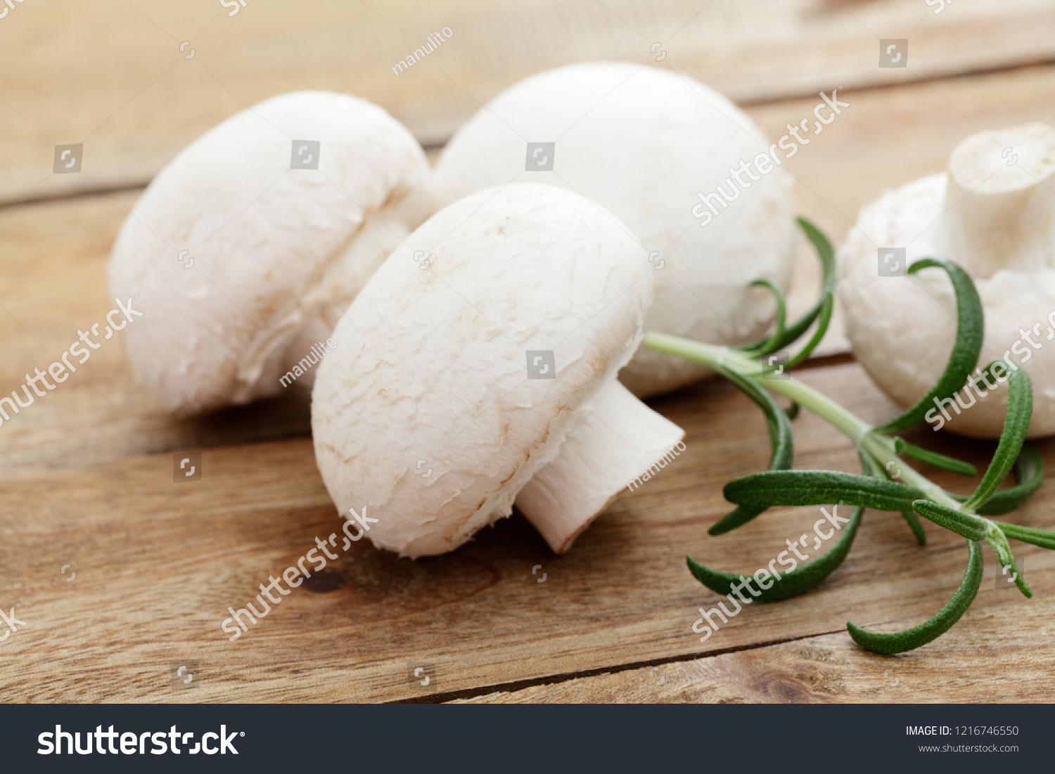 Fresh white mushrooms on a wooden plate
