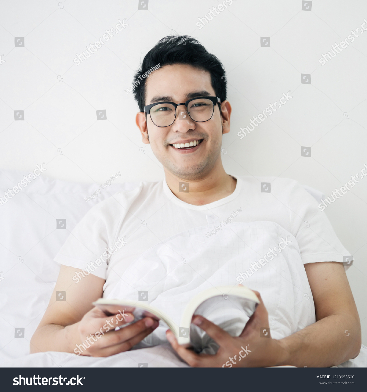 Asian man reading a book on bed in weekend  lifestyle concept.