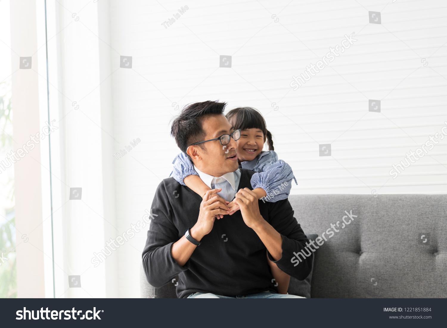 Asian father and daughter playing and hug together in livingroom at home.