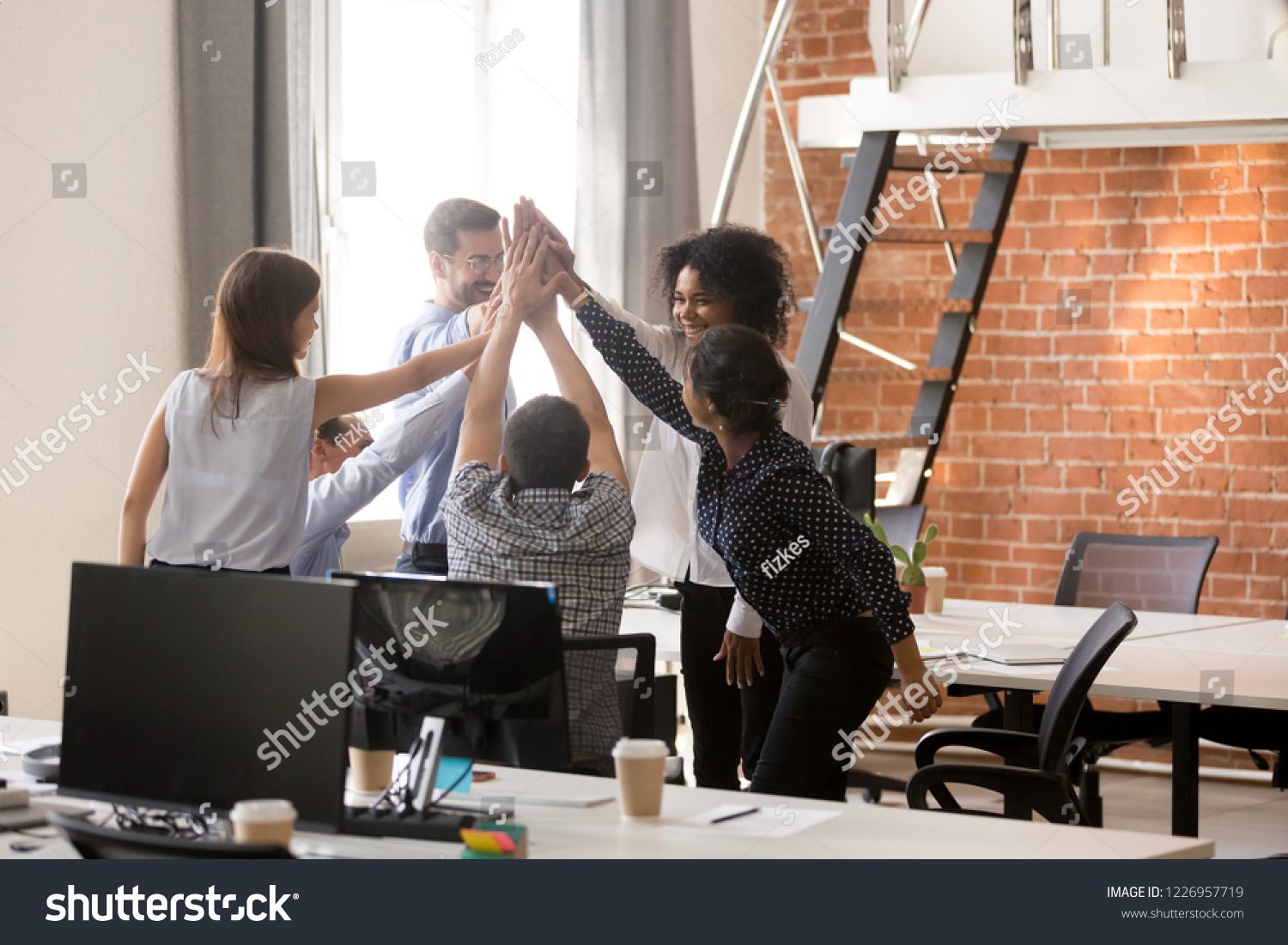 Happy motivated diverse office team giving high five together  excited multi-ethnic employees group celebrating reward  startup success  good teamwork result  engaging in teambuilding concept