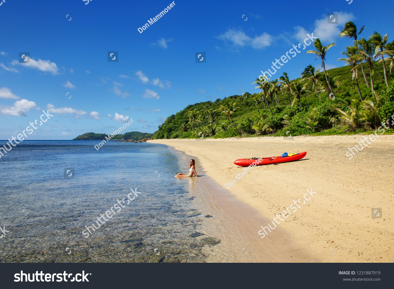 Young woman with red sea kayak on a sandy beach  Drawaqa Island  Yasawas  Fiji