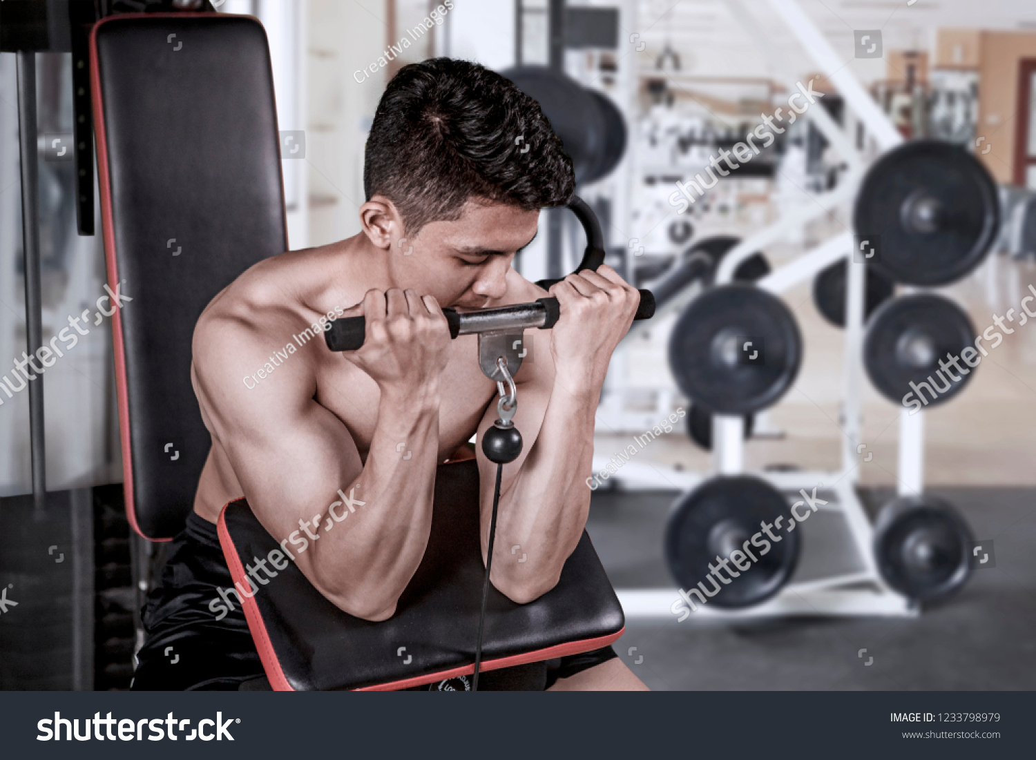 Picture of a young man exercising with a weight machine in the gym center