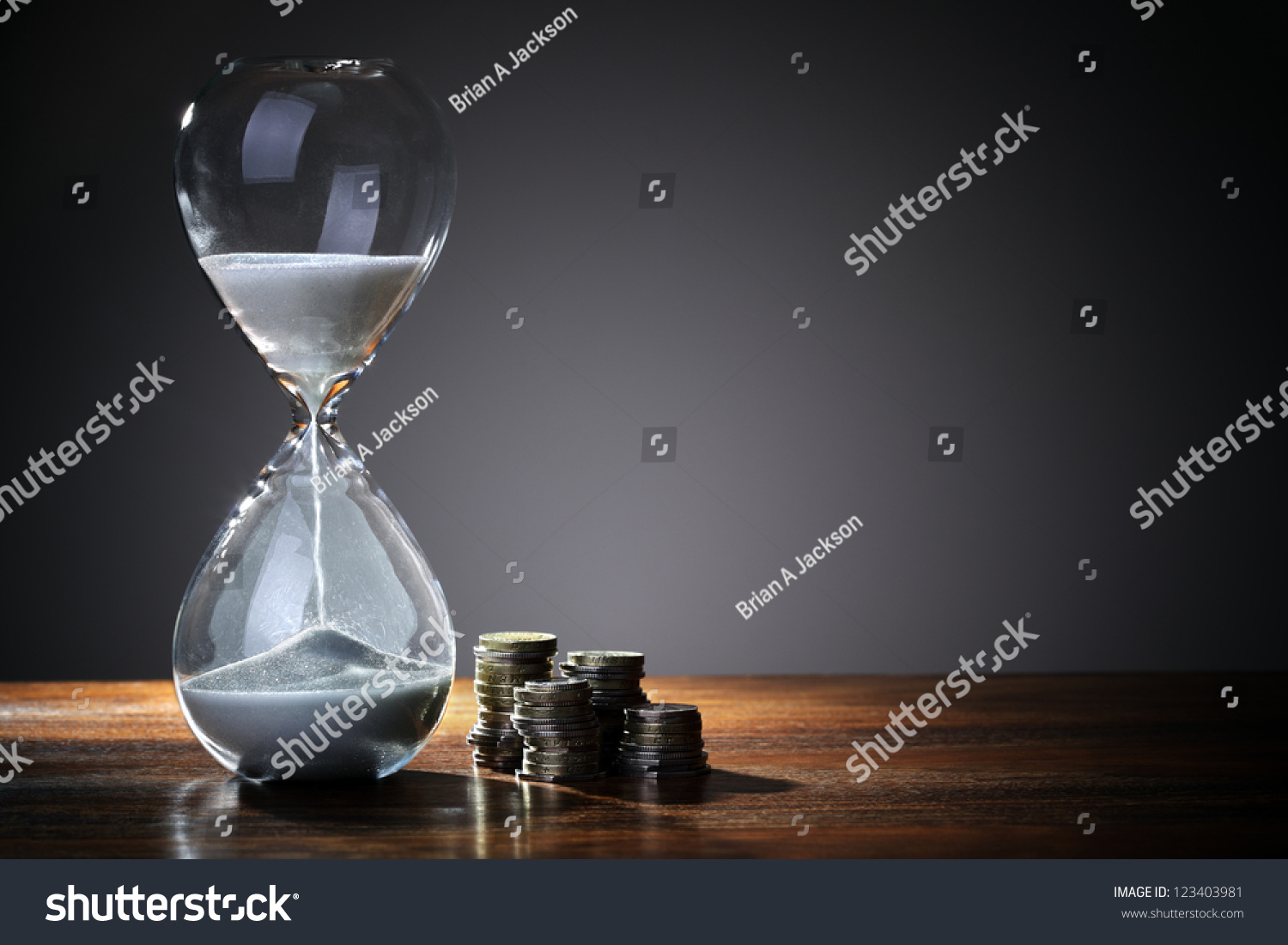 Deadline and time is money concept with hourglass and British coin currency