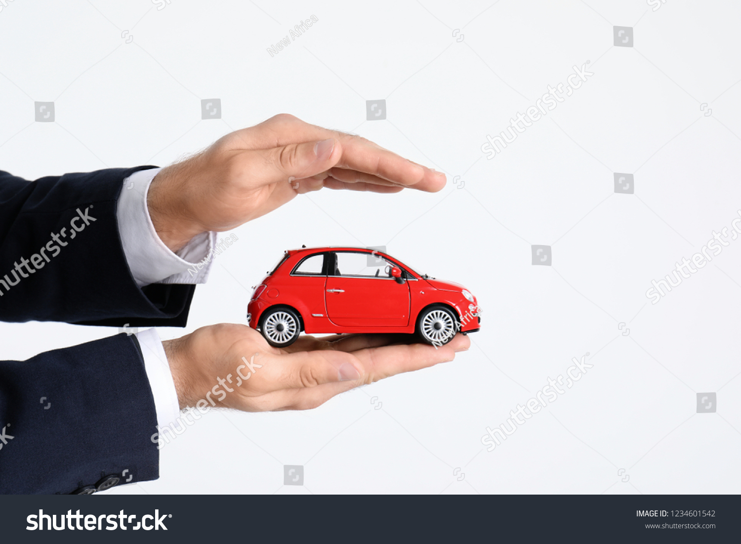 Male insurance agent holding toy car on white background  closeup. Space for text