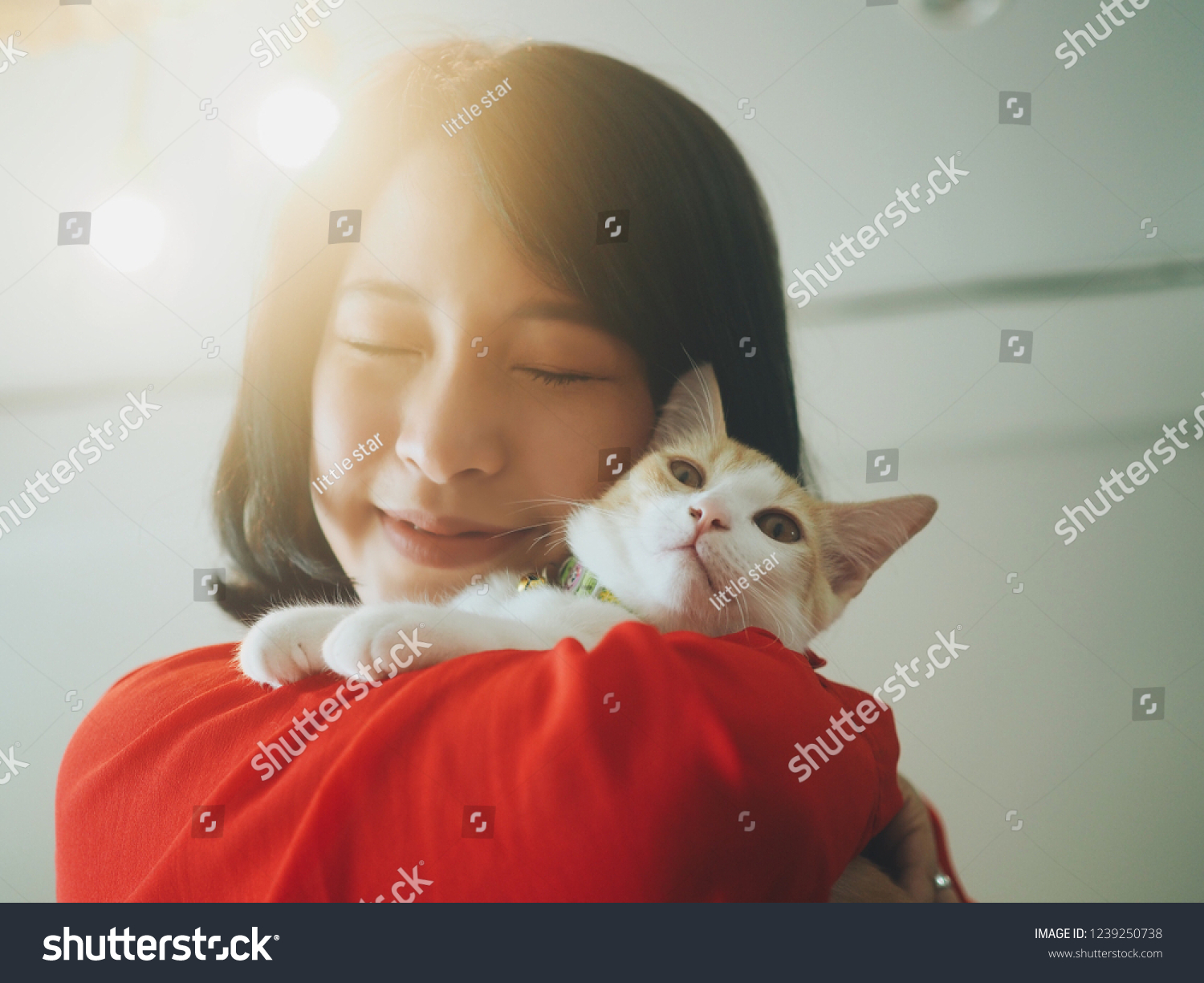 Cute Asian woman holding her kitty at home.