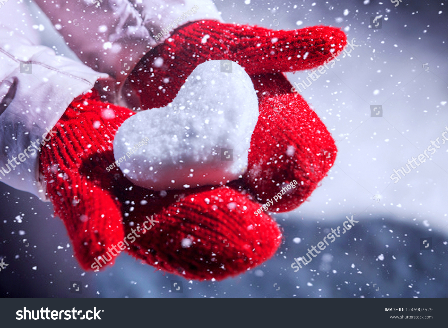 The heart of the snow lies on mittens.