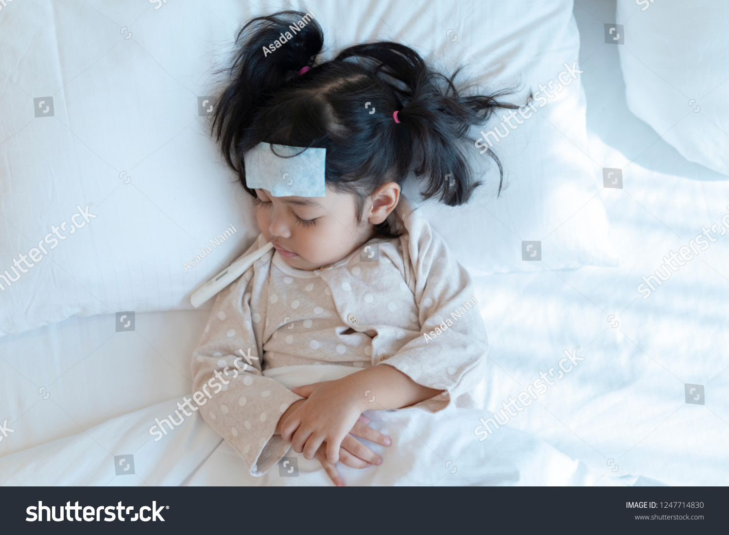 Medical check up and treatment concept. Mother is measure the temperature of little Asian kid girl. Sick child with fever and illness in bed.