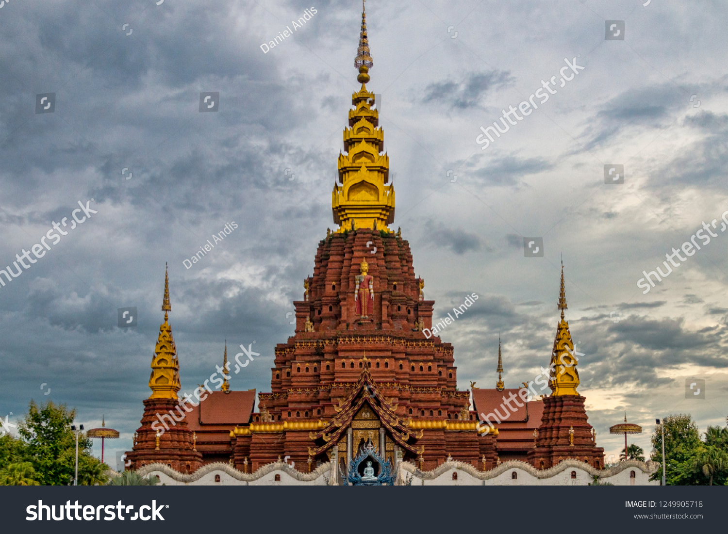 Landscape View of Central Dai Temple and Stupas in Jinghong China. Red Brick Theravada Buddhist Temple with Gold Towers. (Xishuangbanna Yunnan Province China).