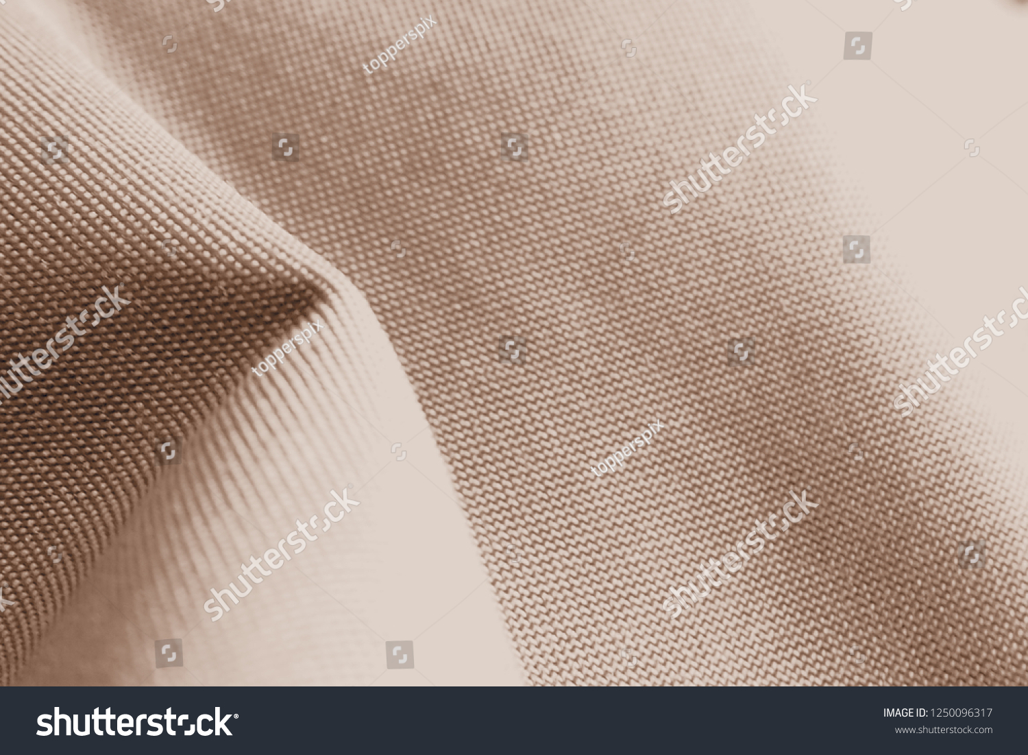 Overexposed and blurred with lighting effect. Closeup of folded polyester quality bag in sepia color adding more brown and golden tone for fabric texture fashion lifestyle and product design concept