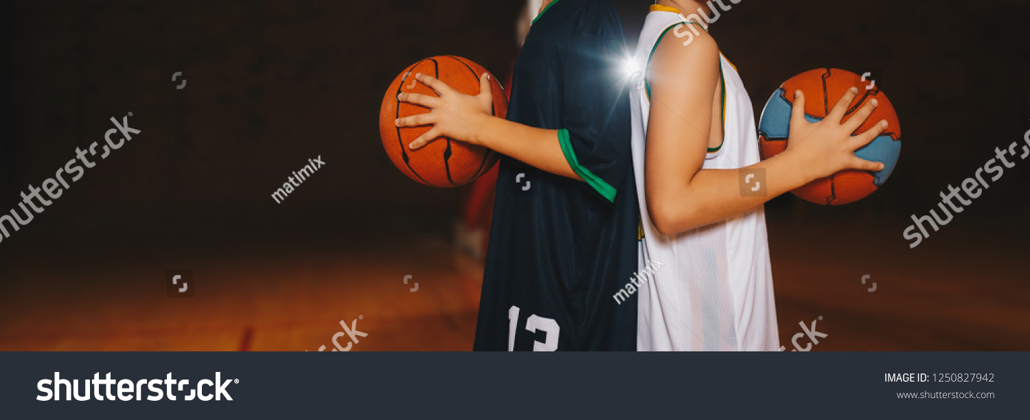 Two Boys Basketball Team Players Holding Basketballs on the Wooden Court. Basketball Training For Kids. Horizontal Background of Youth Basketball Players  Copy Space