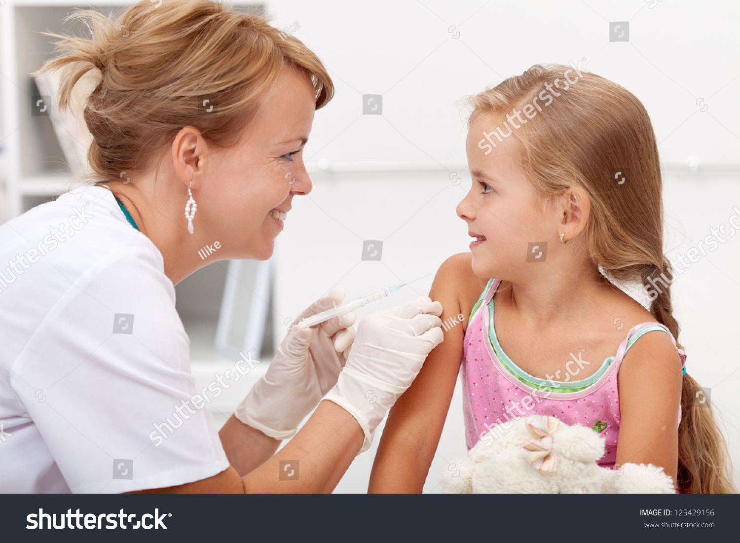 Brave little girl receiving injection or vaccine with a smile