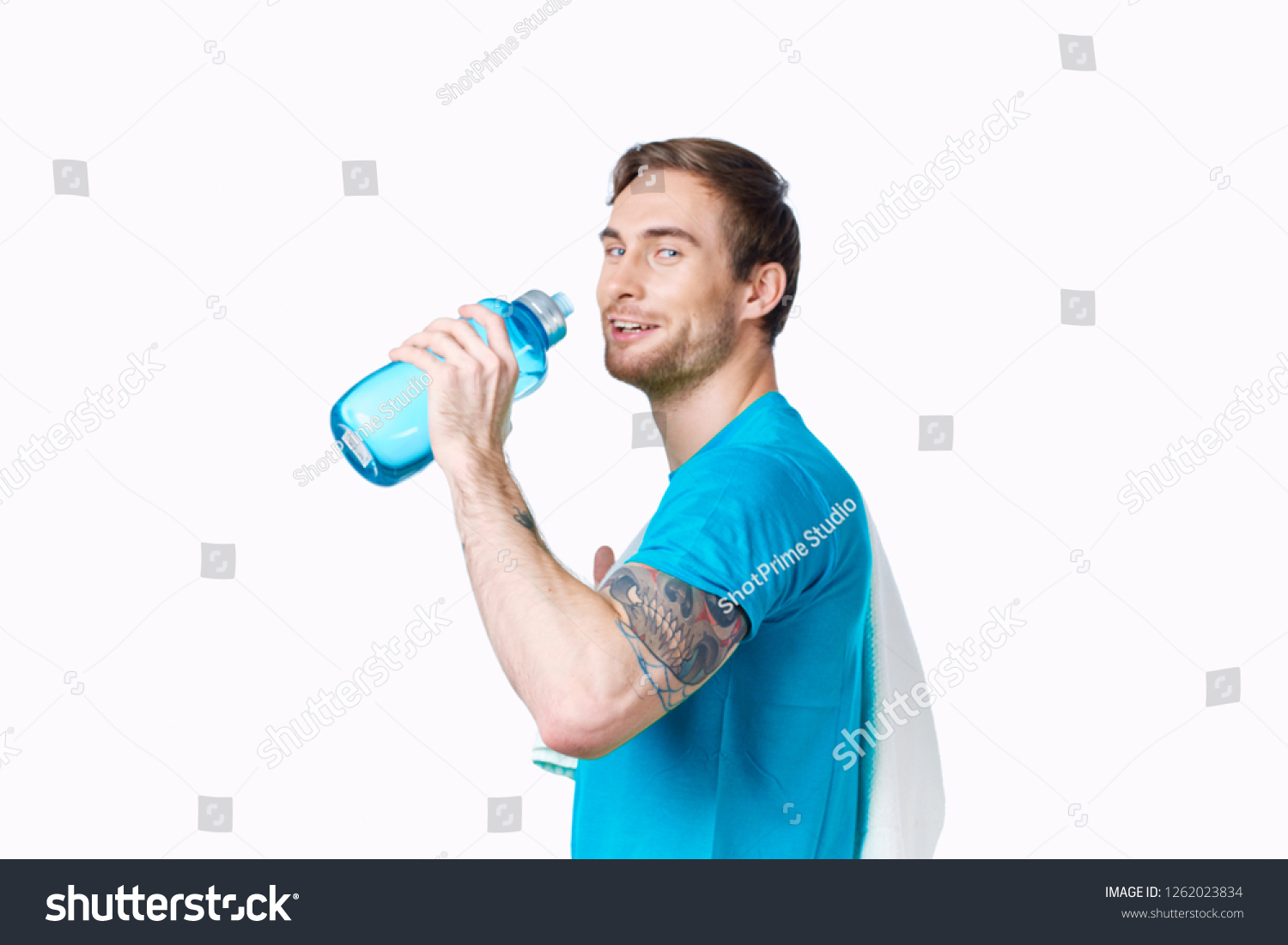 A man is drinking from a blue bottle              