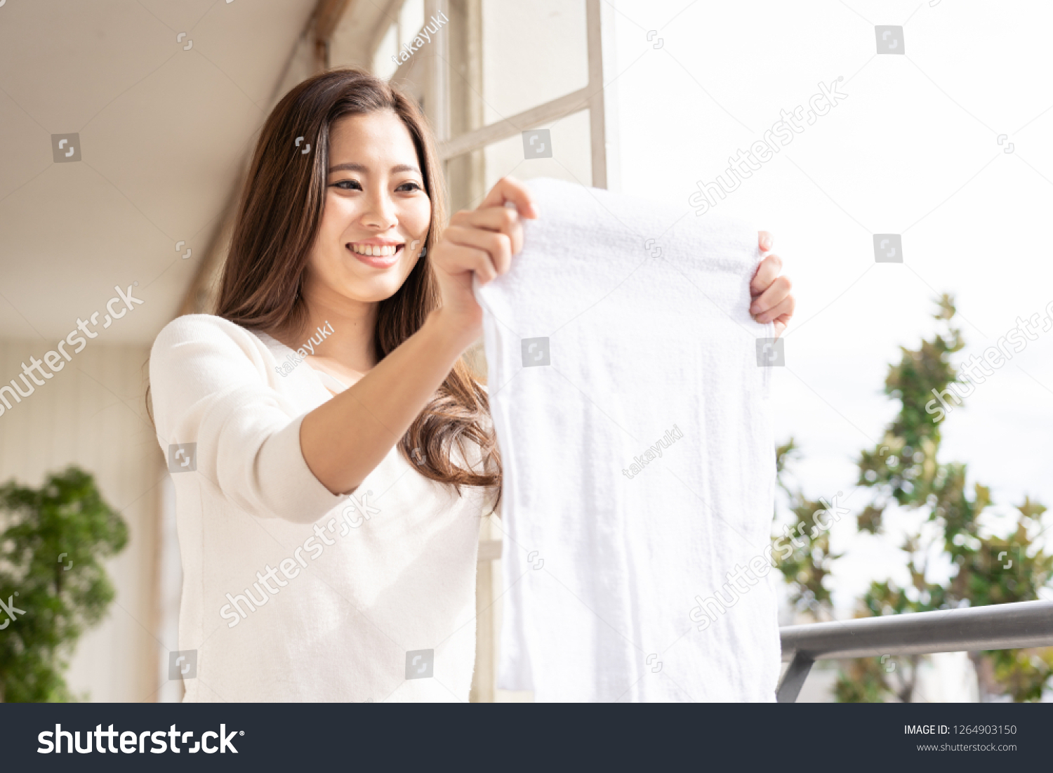 young asian woman hanging the laundly