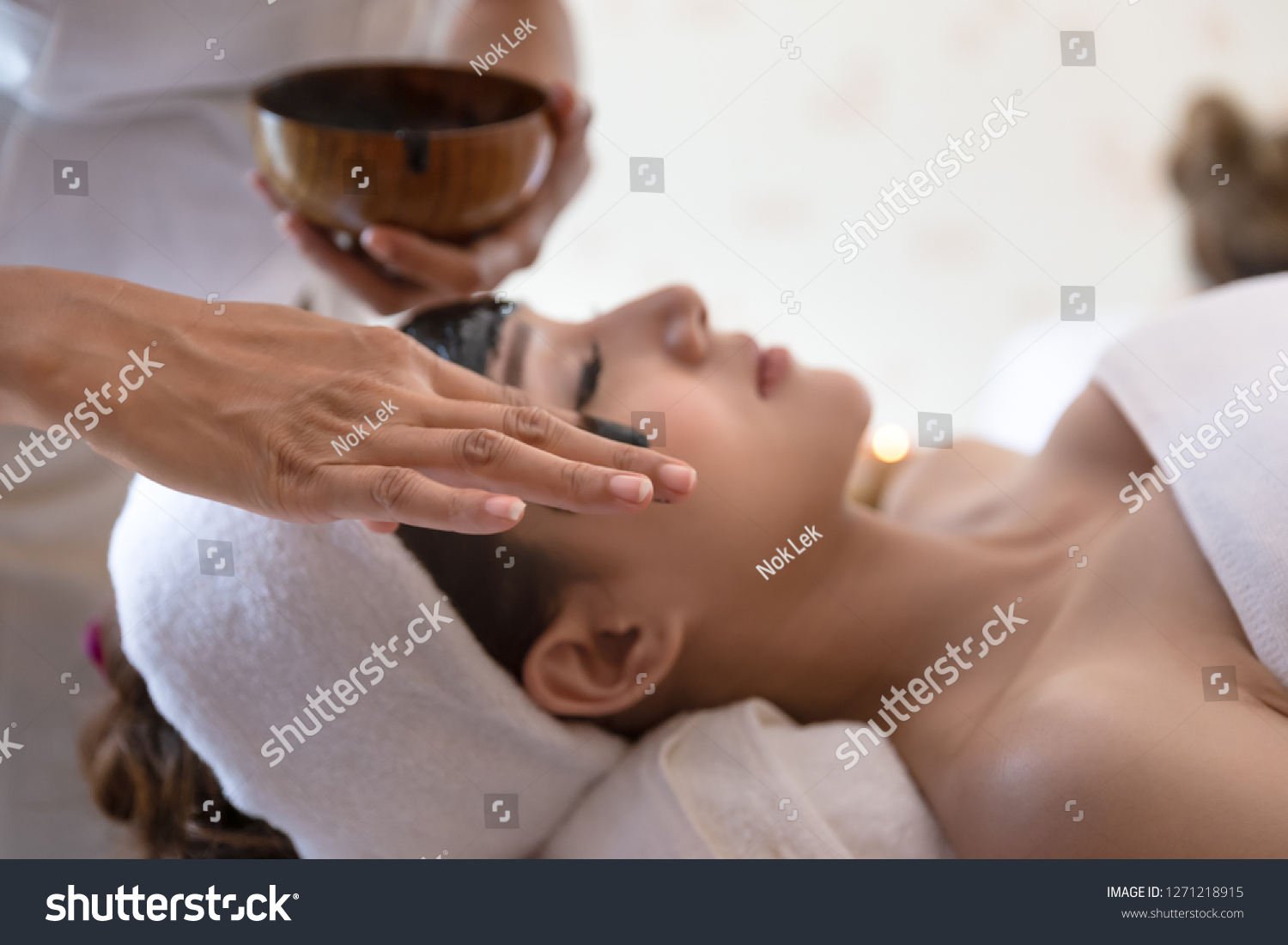Selective focus of masseur hand which Relaxing in spa salon of young woman getting spa treatment at beauty salon spa face massage facial beauty treatment in spa salon.