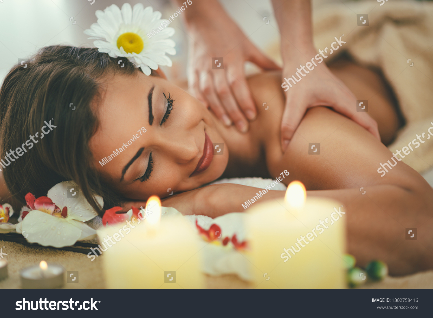 Beautiful woman enjoying during a shoulder massage at a spa. 