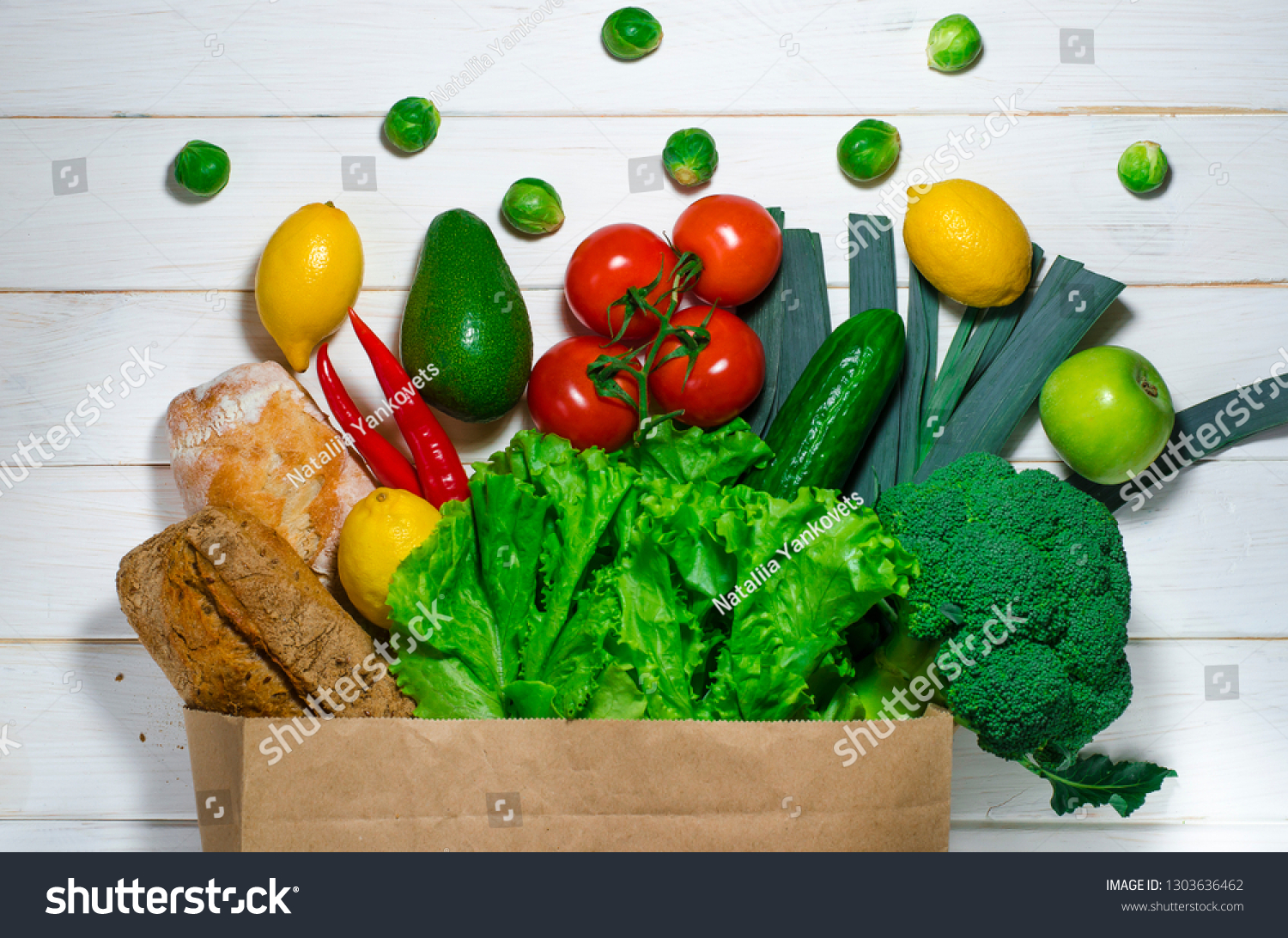 paper bag of different health food on white wooden background.